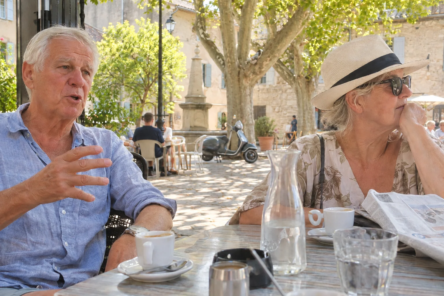 An older couple having coffee on a French village square